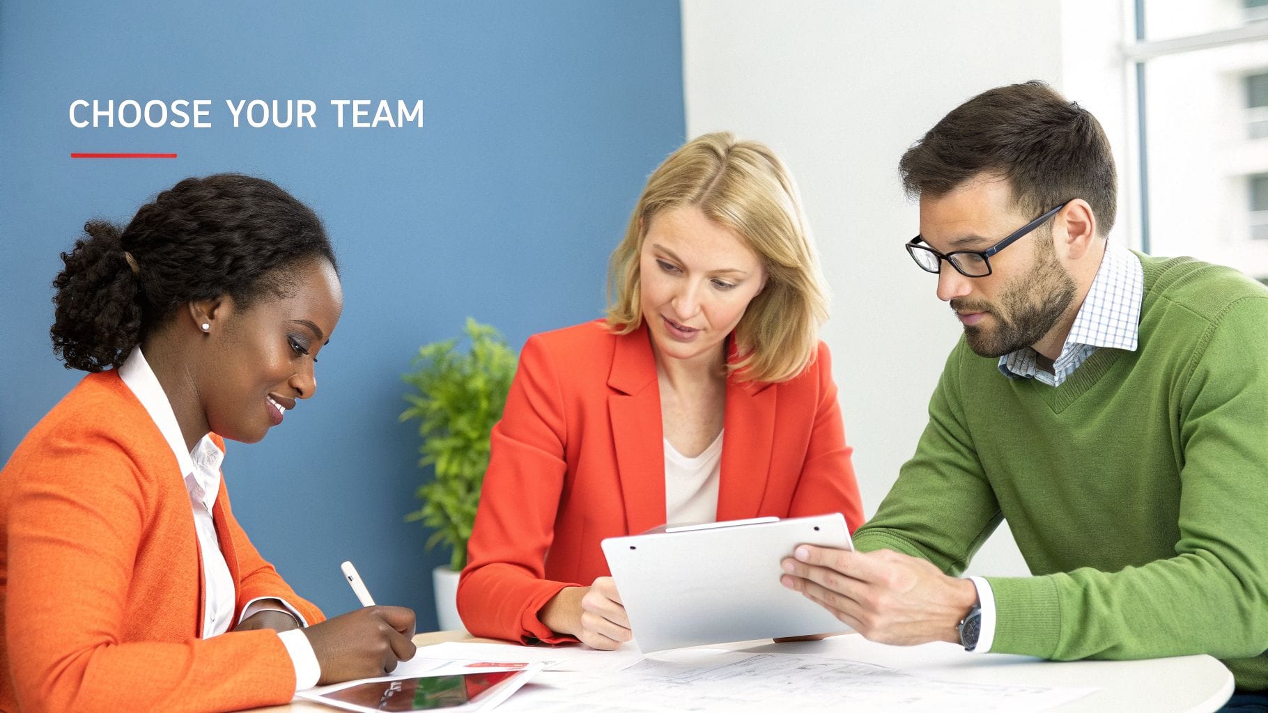 Three diverse business professionals collaborate during a meeting, using tablets and taking notes.