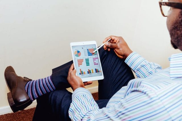 person sitting on chair holding iPad app development small business